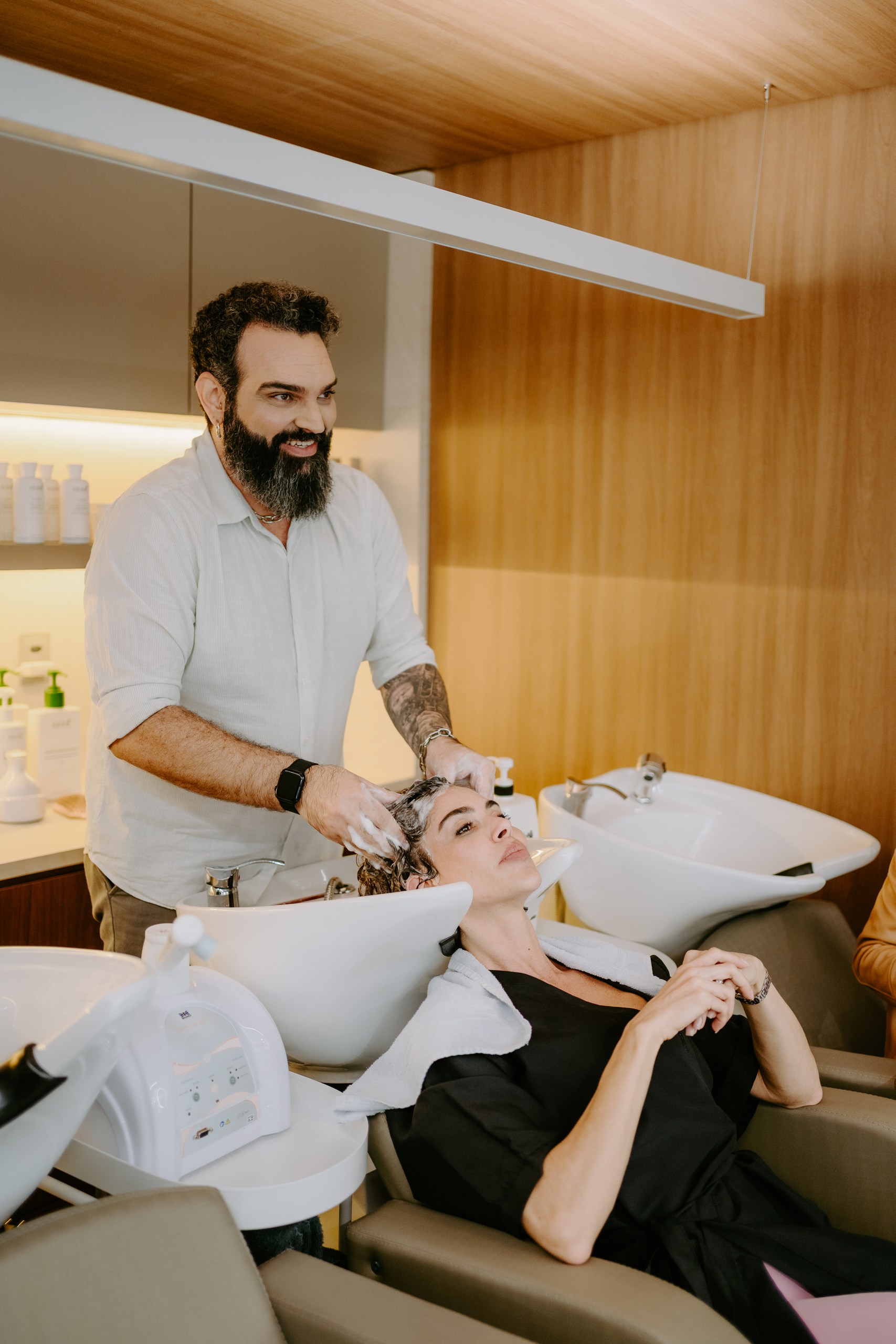 Felipe Messias lava os cabelos de uma cliente no lavatório do DOM Hair