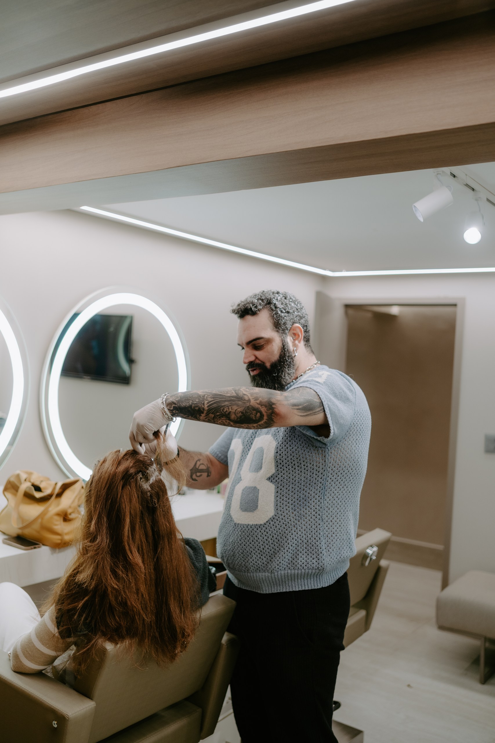 Felipe Messias separa mechas de uma cliente durante a coloração