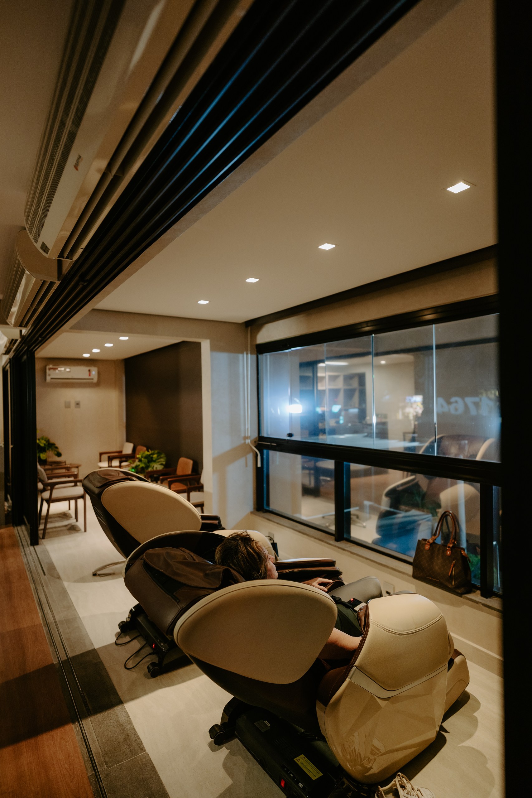 Lounge de relaxamento da clínica, com poltronas reclináveis e luz suave