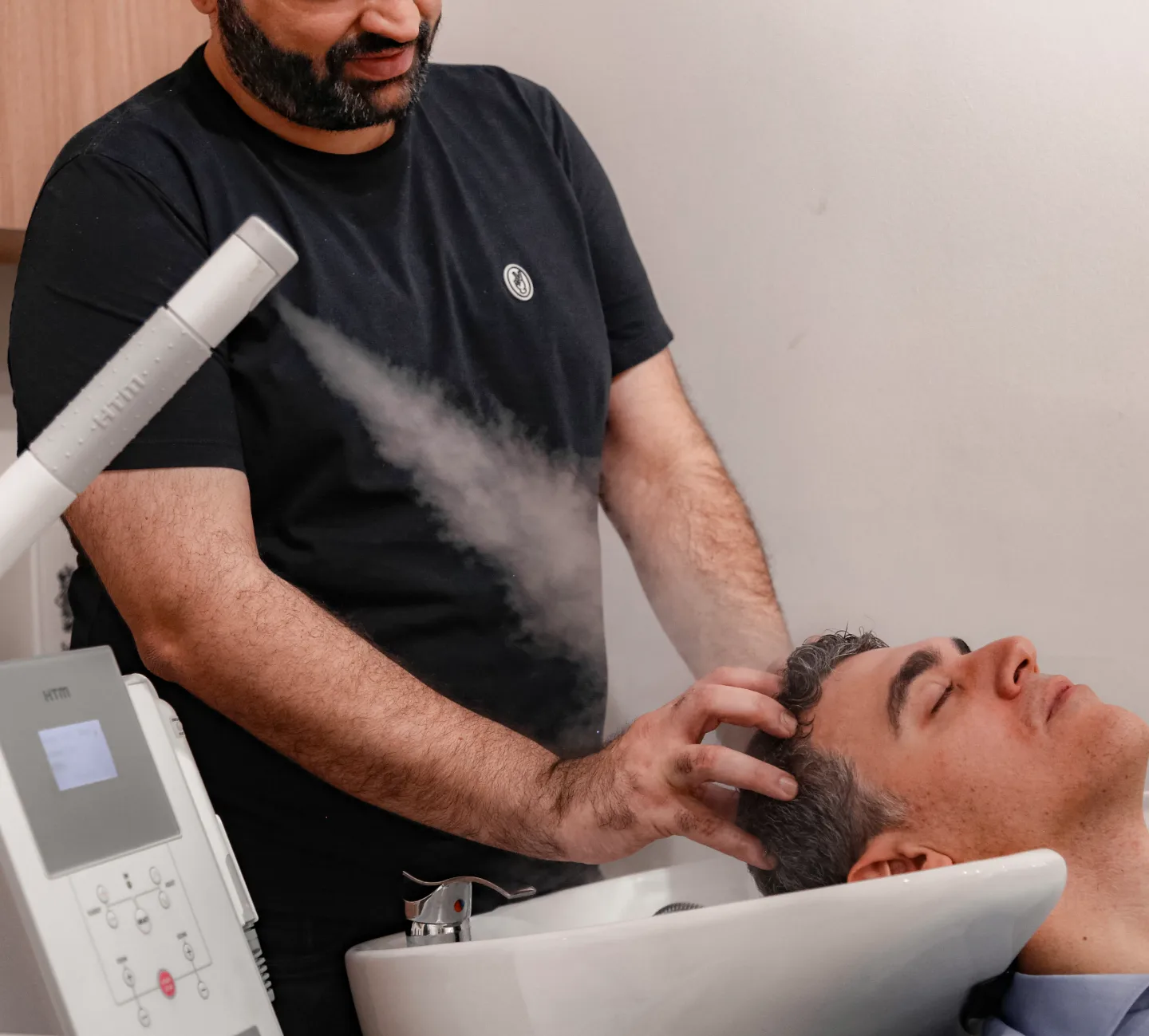 Aplicação de vaporização no couro cabeludo durante tratamento capilar no lavatório